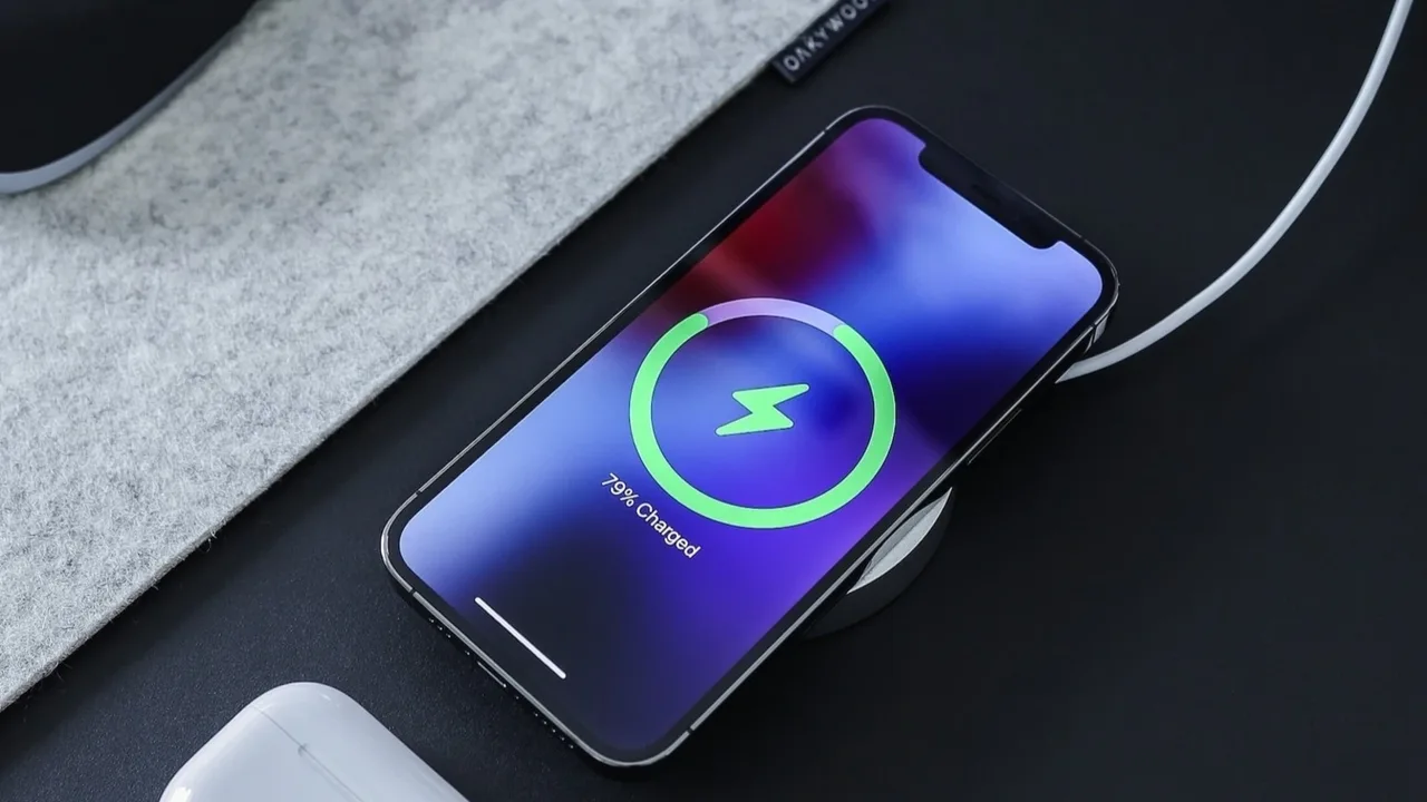 A phone charging on a desk with a battery icon on screen